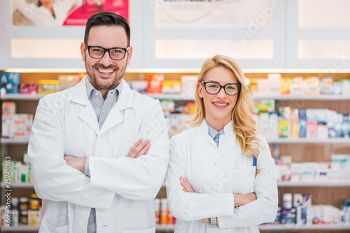 Portrait of a two beautiful young pharmacists at workplace.