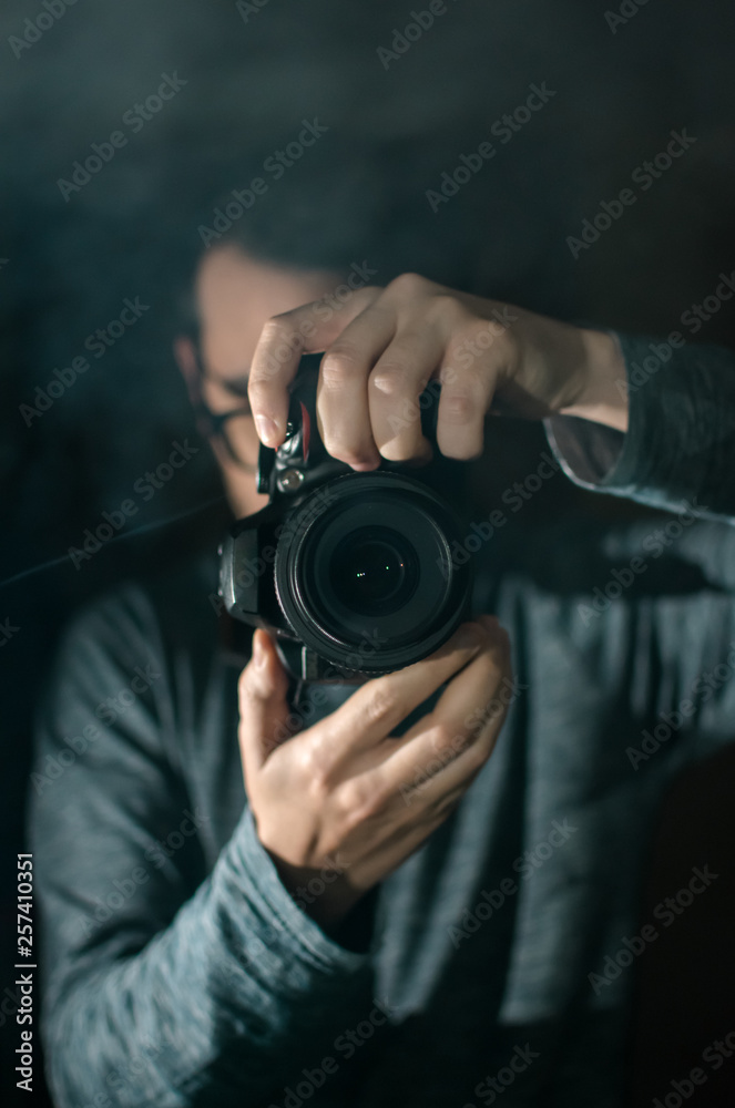 Obraz premium Professional photographer with a camera. Black background.