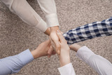 Group of people holding hands on light background. Unity concept