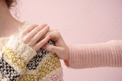 Young woman comforting her friend on color background photo