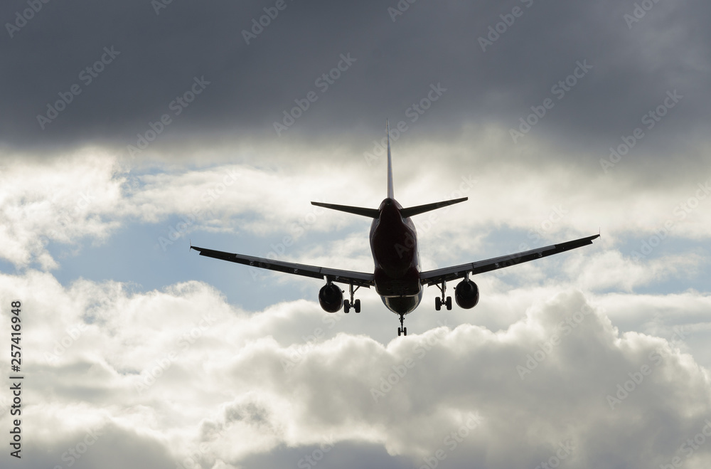 Airplane flying in sky with clouds at sunset time