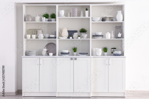 Open cupboard with clean dishes in kitchen