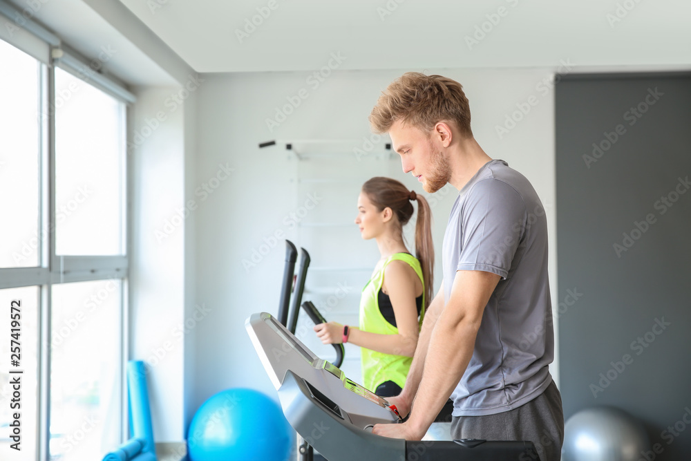 Sporty young people training on machines in gym Sporty young people training on machines in gym