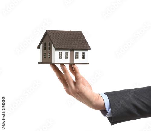Insurance agent with model of house on white background. Protection of house from earthquake