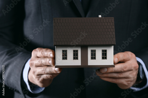 Businessman Holding Miniatu...