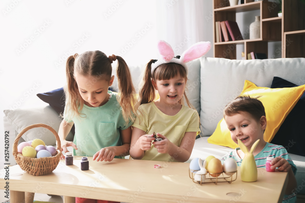 Fototapeta premium Cute little children painting Easter eggs at home