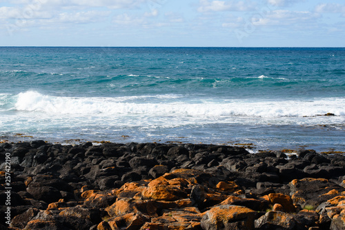 View of ocean waves with black rocks in foreground, Port Fairy Victoria Australia