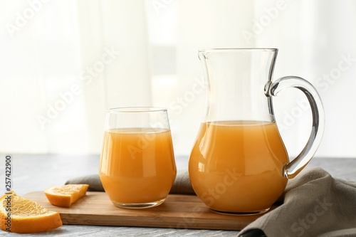 Jug and glass of orange juice on table