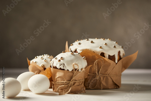 delicious easter cakes and chicken eggs on white table with copy space