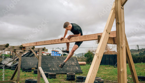 Male participant in a obstacle course doing irish table obstacle