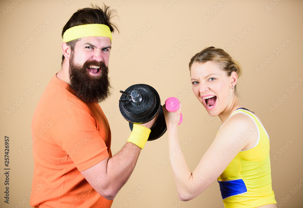 Defend til the End. Sporty couple training in gym. Sport dumbbell equipment. Athletic fitness competition. Weight lifting. Happy woman and man workout with barbell. Strong muscles and power