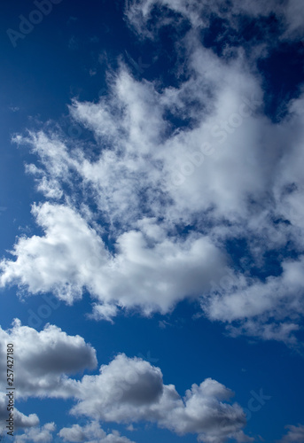 White fluffy clouds in bright blue sky minimal