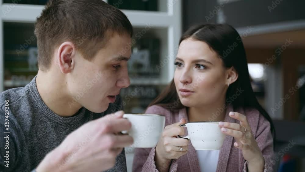 A guy and a girl are sitting together in a cafe. They drink tea. They are in love with each other. Couple in love. A guy and a girl are sitting together in a cafe. They drink tea. They are in love with each other. Couple in love.