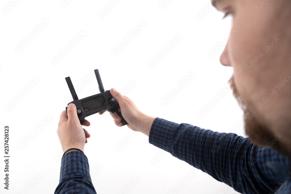 Man holds the remote control from the quadcopter on a white background Man holds the remote control from the quadcopter on a white background