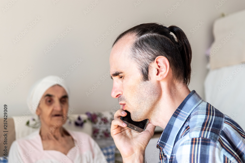 Caucasian man with stubbly beard talking and receiving bad news on the phone Caucasian man with stubbly beard talking and receiving bad news on the phone