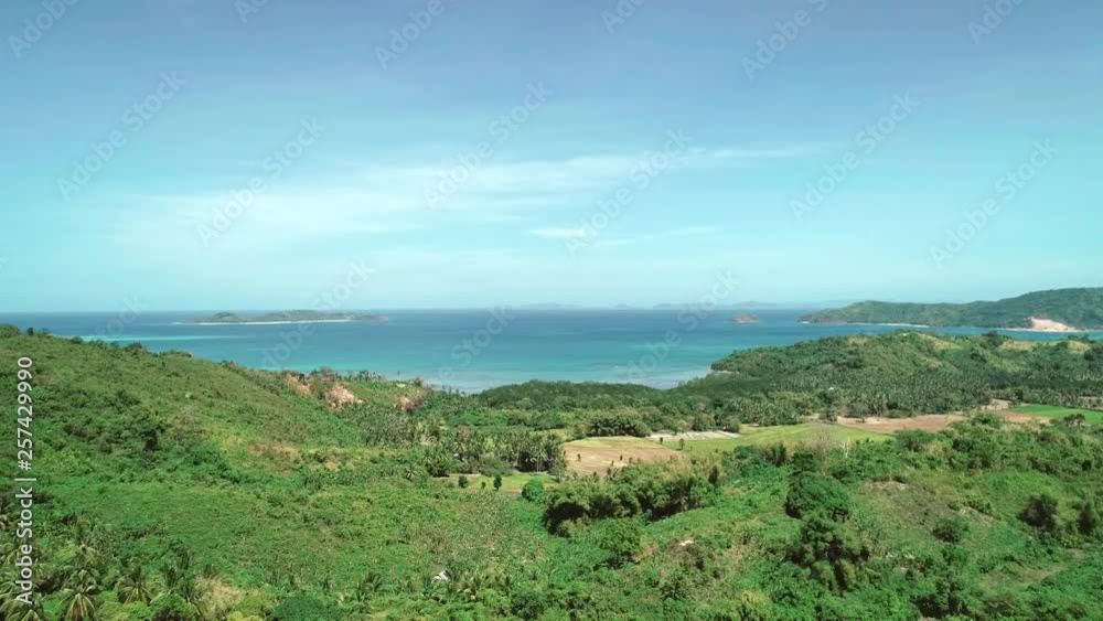 Aerial drone flight over mountains covered with tropical forest on sunny day. Tropical paradise bay with blue water on the background. Palawan island, Philippines. Aerial drone flight over mountains covered with tropical forest on sunny day. Tropical paradise bay with blue water on the background. Palawan island, Philippines.
