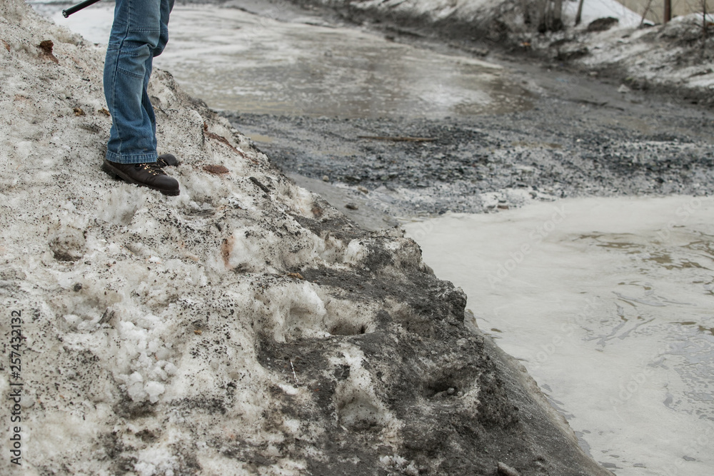 warming in early spring, snow melts turning into slush and puddles underfoot, which bypass the pedestrians walking on the sidewalk and crossing the road with wet feet warming in early spring, snow melts turning into slush and puddles underfoot, which bypass the pedestrians walking on the sidewalk and crossing the road with wet feet