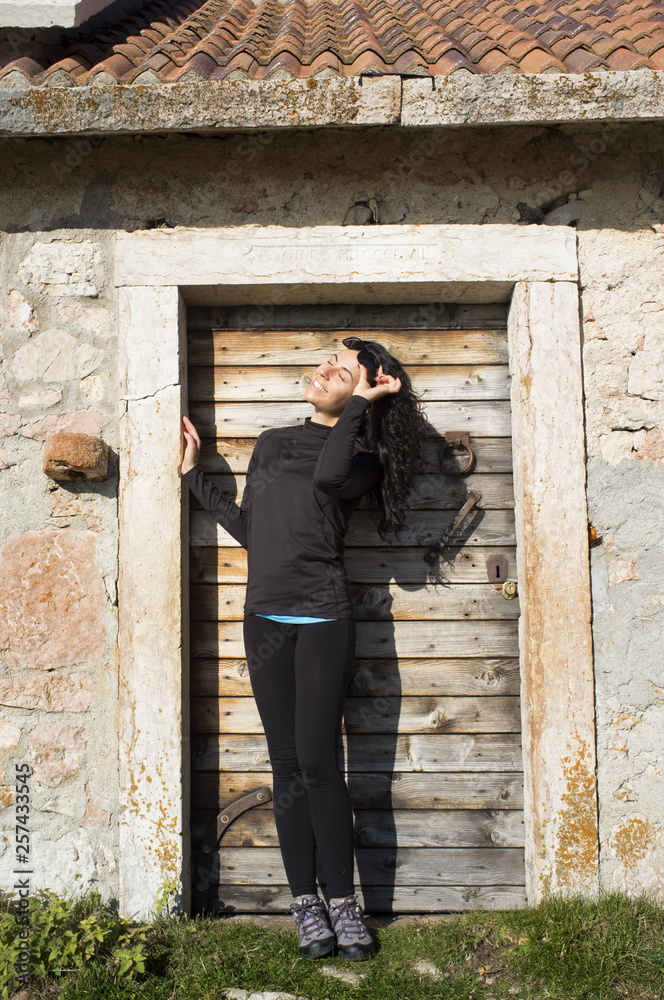 break during the mountain ascent / happy girl near the old mountain stall door during a mountain ascent