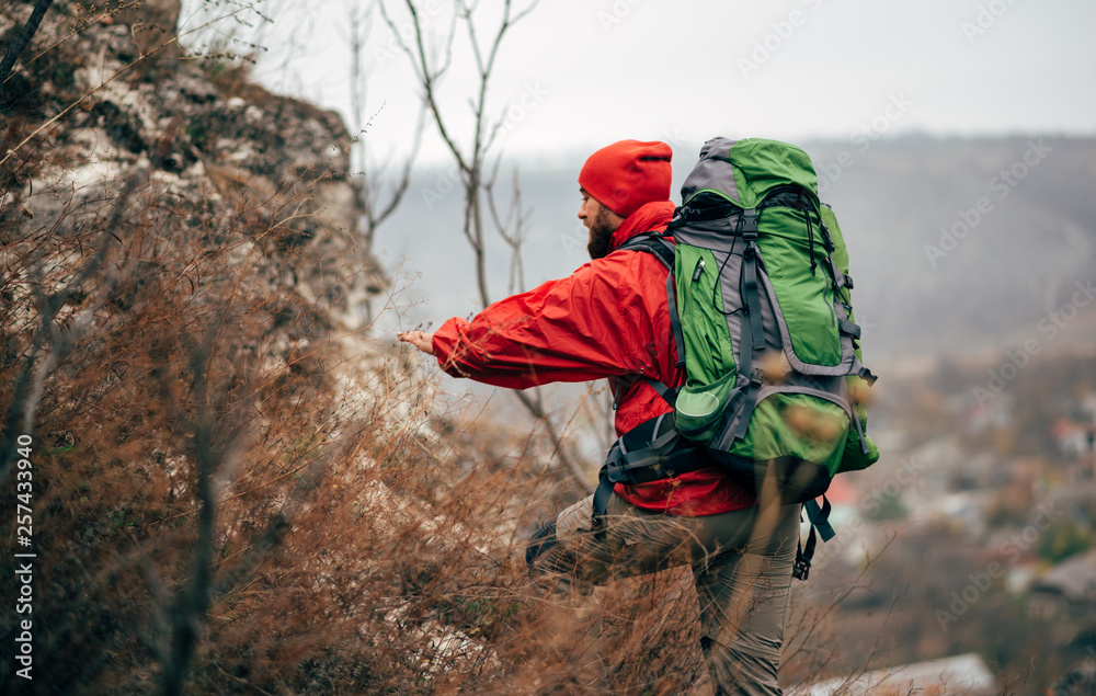 Rear view of young hiker man hiking in mountains dressed in red clothes  exploring new places. Traveler bearded male trekking and mountaineering  during his journey. Travel, people, sport, lifestyle Photos | Adobe
