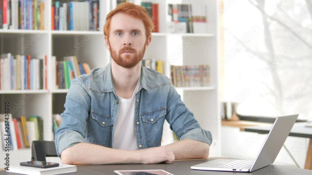 Serious Casual Redhead Man Sitting at Work Serious Casual Redhead Man Sitting at Work