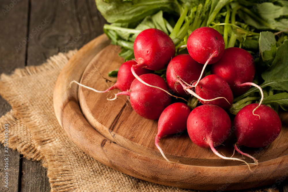 Fresh bunch of radishes on wooden rustic background