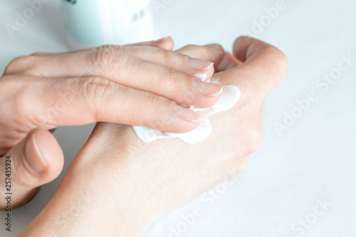 Female hands applying hand cream.