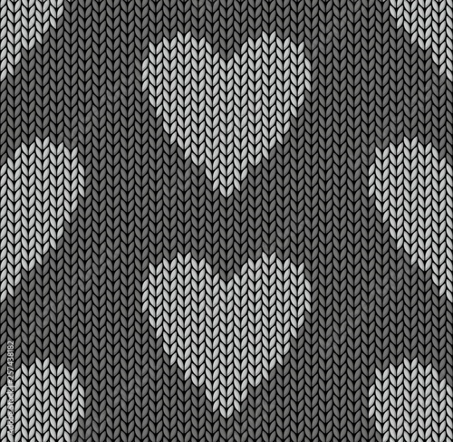 The Seamless gray knitted background with hearts.