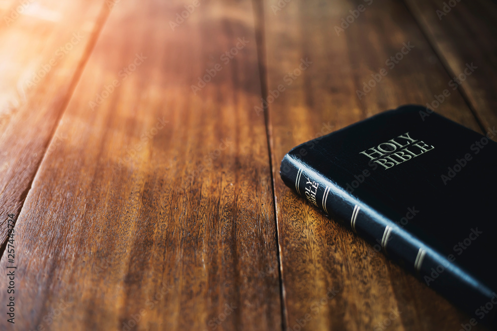holy bible on wooden table background with soft morning sun light Stock