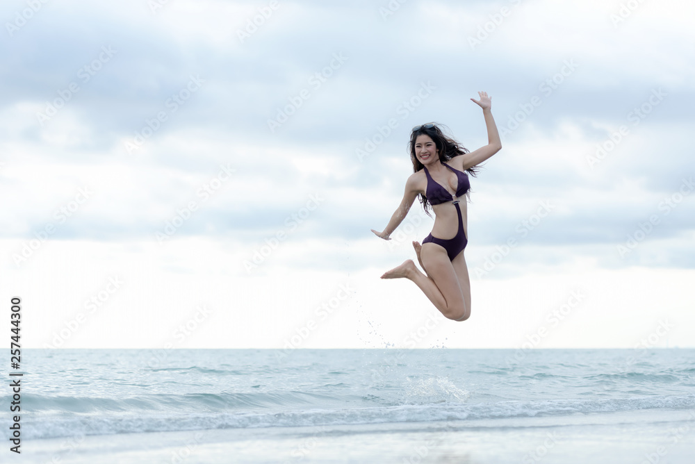Summer holiday vacation concept. Traveler woman lifestyle in bikini jumping and enjoying relaxing on destinations sea beach Summer holiday vacation concept. Traveler woman lifestyle in bikini jumping and enjoying relaxing on destinations sea beach