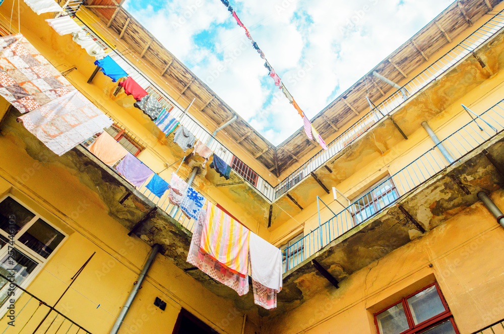 Linen is Dried on Clothesline on a Background of Blue Sky with Clouds. Sunny day in the Yard-Well. Old Building Facade Linen is Dried on Clothesline on a Background of Blue Sky with Clouds. Sunny day in the Yard-Well. Old Building Facade