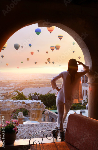 Girl at dawn watching the balloons and enjoying life. Cappadocia, Goreme, Turkey 