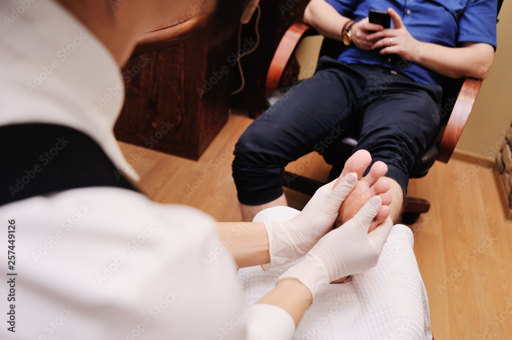 young female pedicure master doing finger nail care customer men on spa salon background young female pedicure master doing finger nail care customer men on spa salon background