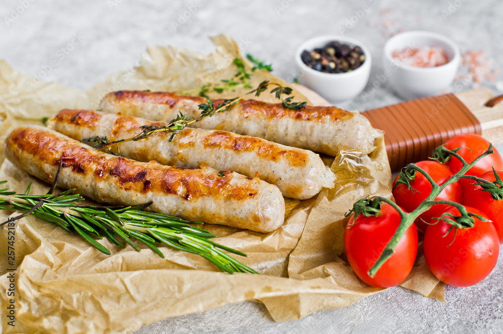 Fried chicken sausages on a wooden chopping Board. Gray background, side view