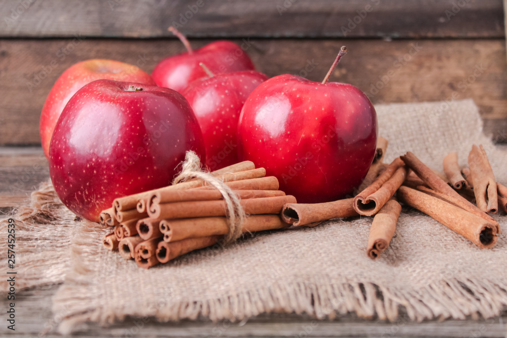 cinnamon sticks and apples on wooden background cinnamon sticks and apples on wooden background