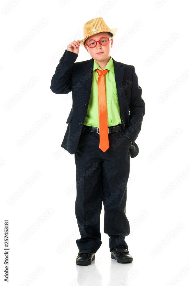 Funny boy schoolboy in a business suit, bright tie and funny glasses and a hat emotionally dancing on an isolated white background Funny boy schoolboy in a business suit, bright tie and funny glasses and a hat emotionally dancing on an isolated white background