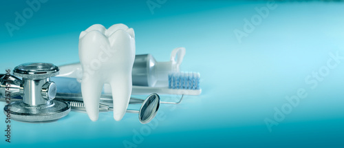 White big healthy tooth and different tools for dental care and stethoscope, on gradient dental background. banner size