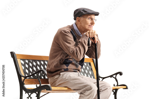 Quadro em tela Senior man with a walking cane sitting on a bench and thinking