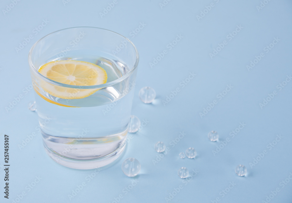 water with lemon on the blue table with crystal beads water with lemon on the blue table with crystal beads