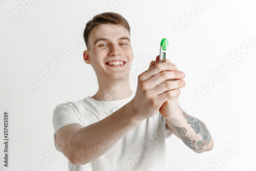 Happy man looking at pregnancy test at studio. Human emotions concepts