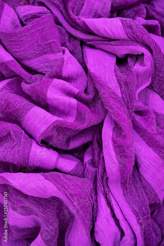 Vertical photo of a fragment of folds of fabric of lilac color