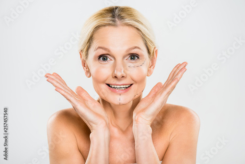 Billede på lærred beautiful and surprised woman with lines on face looking at camera and showing s