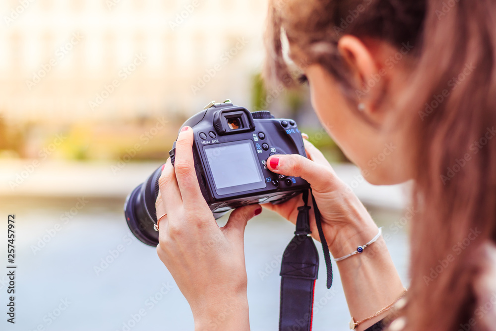 Young female tourist girl is taking shots with her camera - obrazy, fototapety, plakaty 