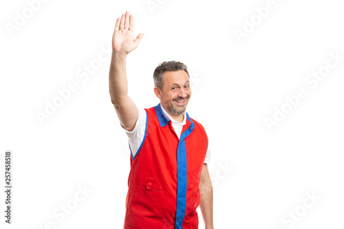 Supermarket worker with palm up as hello gesture.