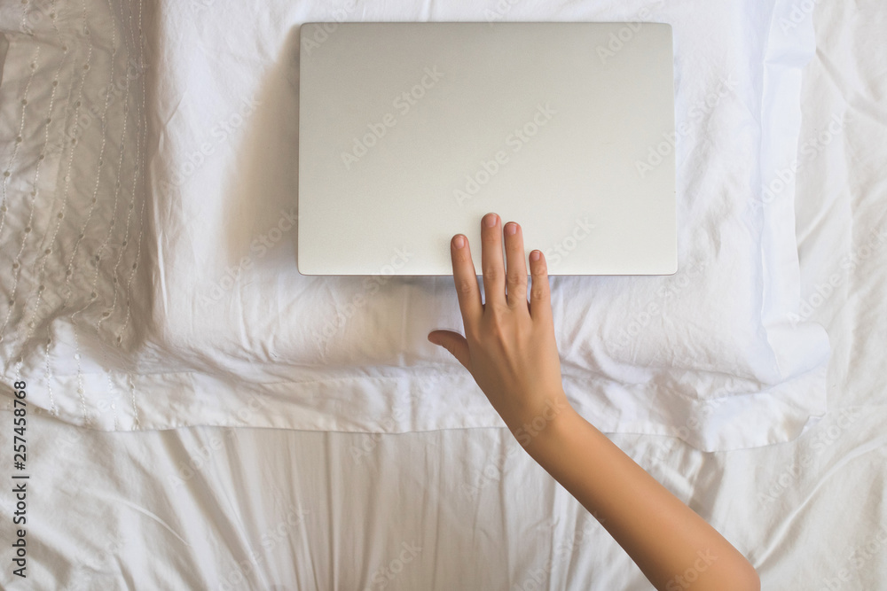 Girl lying with a laptop can't sleep and have to work late at night. Top view Girl lying with a laptop can't sleep and have to work late at night. Top view