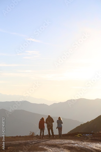 3 friends watching the sunset on mountain top © murat