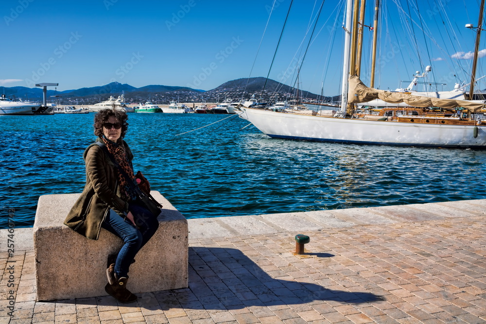 Frau sitzt am Hafen von Saint Tropez, Frankreich