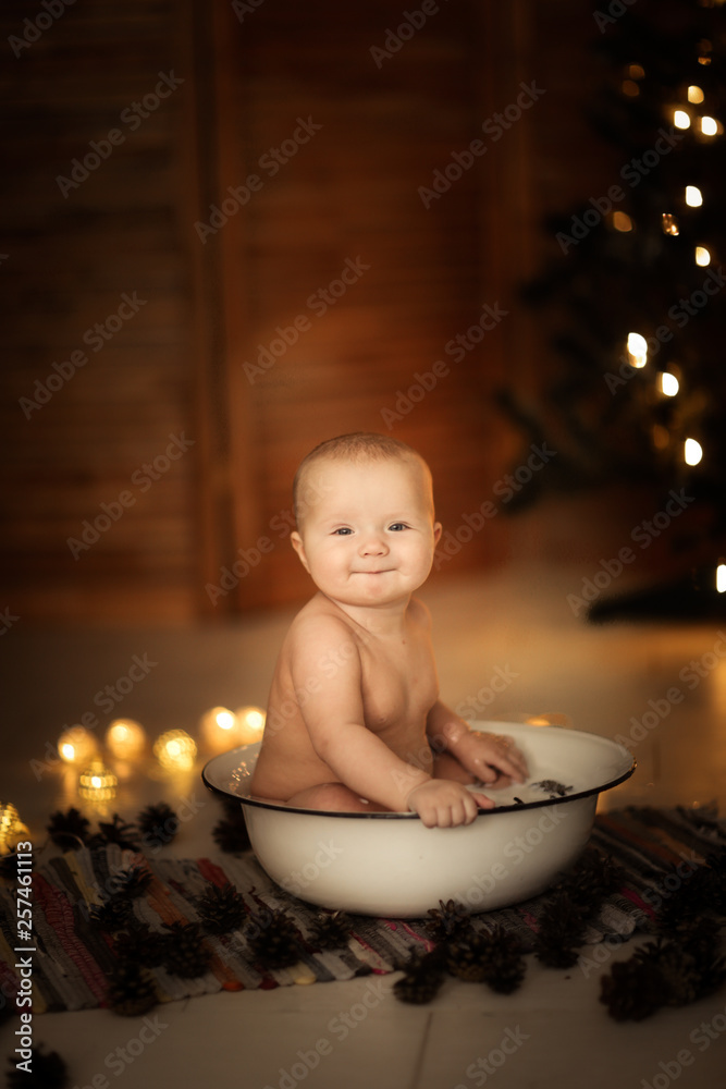 Baby bathed in milk in an iron basin with cones Baby bathed in milk in an iron basin with cones