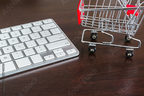 Shopping trolley with keyboard on dark brown table