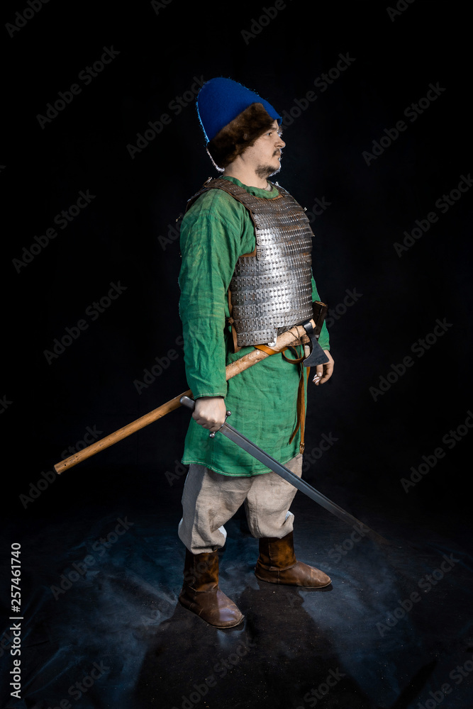 slavic viking age warrior in armor and vintage hat with sword and ax Stock  Photo | Adobe Stock