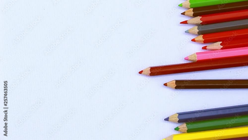 Close up of colorful pencils are rolling on white paper background. with copy spaces. Close up of colorful pencils are rolling on white paper background. with copy spaces.